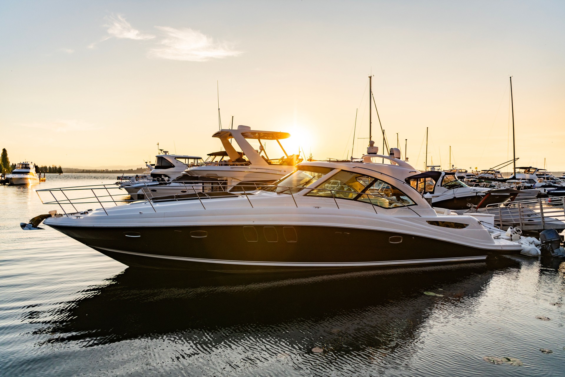 Luxury yacht in the evening sunset. Yacht club marina. Summer vacation. Downtown city marina with luxury yacht. Docked vessels. Luxury yacht in sunset marina