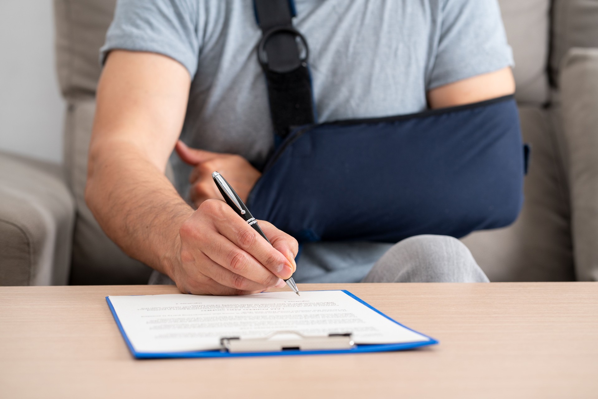 handicapped man with sling signing contract at home